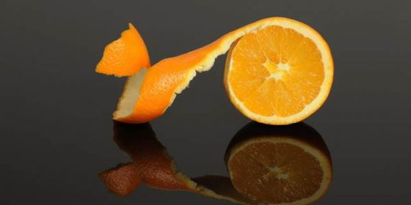 Half Orange peeled isolated on a gray reflective surface; Shutterstock ID 67203511; PO: aol; Job: production; Client: drone