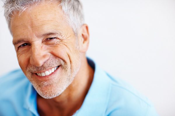Closeup portrait of a happy mature man on white background